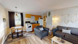a living room with a couch and a kitchen at Lakeside Stays in Plaster Rock