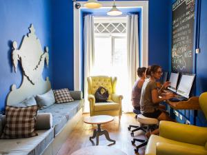 two women sitting in a room with their laptops at Goodmorning Solo Traveller Hostel in Lisbon