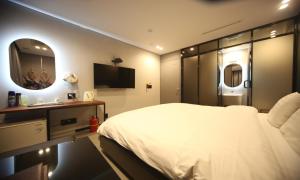 a bedroom with a large white bed and a mirror at Life Style S Hotel in Seoul