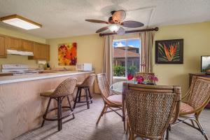 a kitchen with a table and chairs and a counter at Pono Kai J107 in Kapaa