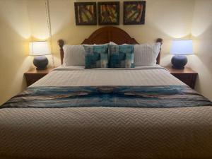 a bedroom with a large bed with two lamps at Pono Kai J107 in Kapaa +50 photos