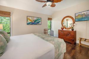 a bedroom with a white bed and a mirror at Lae Nani 123 in Wailua +15 photos