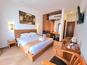 a bedroom with a large bed and a desk at Satriya Cottages in Kuta +88 photos