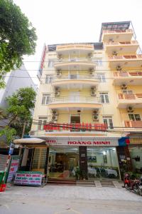 Un gran edificio amarillo con un cartel de ministerio de asombro en él. en Khách Sạn Hoàng Minh, en Sầm Sơn