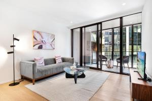 a living room with a couch and a table at Spacious Modern Apartment with Pool & Gym Access in Melbourne