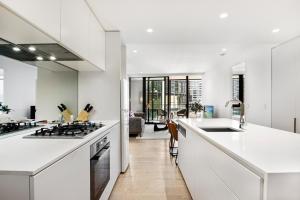 a kitchen with white counters and a stove top oven at Spacious Modern Apartment with Pool & Gym Access in Melbourne +7 photos