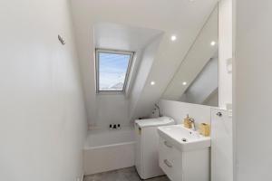 une salle de bain blanche avec toilettes et lavabo dans l'établissement Útulný apartmán s klímou, à Bratislava 3 autres photos
