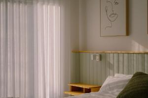 a bedroom with a bed and a window with curtains at Monument House in Daylesford