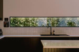 a kitchen with a sink and a large window at Monument House in Daylesford +27 photos