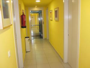 a hallway with yellow walls and a hallway with a fire extinguisher at Hotel Blauet by Bossh Hotels in El Prat de Llobregat