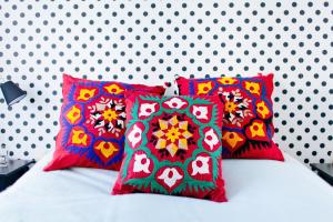 a bed with four colorful pillows on it at B&B Place Jourdan in Brussels