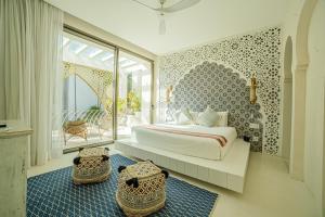 a bedroom with a king sized bed and a balcony at Sana Tulum Beachfront Boutique Hotel in Tulum