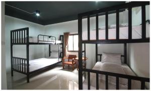 a room with two bunk beds and a table with a chair at Hometel Hotel in Krabi town