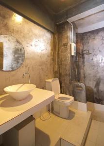 a bathroom with a sink and a toilet at Hometel Hotel in Krabi town