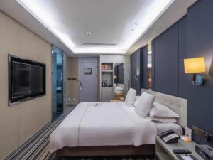 a large bedroom with a large bed and a television at Urumqi Bayinhe Hotel in Ürümqi