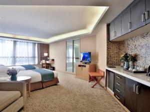 a large hotel room with a bed and a kitchen at Jinhua World Trade Hotel in Jinhua