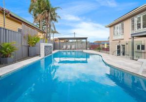 una grande piscina blu accanto a un edificio di Shellharbour Poolside Escape a Shellharbour