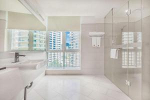 ein Bad mit einem Waschbecken und einer Dusche mit Fenstern in der Unterkunft Guangdong Workers Santorium-Sea Side Park K Building Hotel in Pingshan + 276 Fotos