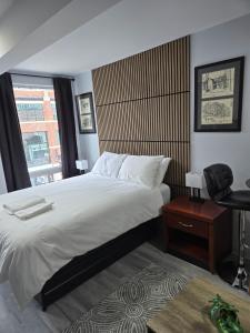 a bedroom with a bed and a chair and a window at CDQI Hotel in Ottawa