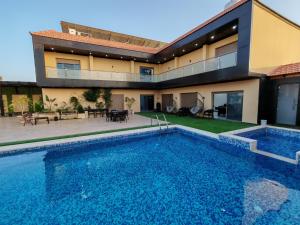 a swimming pool in front of a house at Wonder Villa in Al Rama