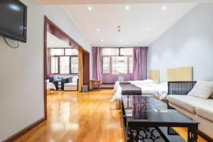 a room with a bed and a couch and a table at Pai Hotel Tianjin Binguan Metro Station Municipal Government in Tianjin