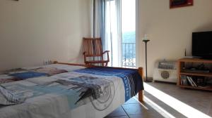 a bedroom with a bed and a television and a balcony at Apartment Bigovo in Tivat