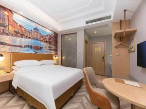 a bedroom with a large bed and a desk and a table at Vienna Suzhou Oriental Gate Jinji Lake in Suzhou