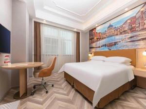 a hotel room with a bed and a desk at Vienna Suzhou Oriental Gate Jinji Lake in Suzhou