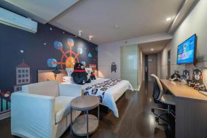 a bedroom with a bed and a couch and a desk at Jinjiang Inn Select Xuzhou Suning Plaza Jinguang East Road in Xuzhou
