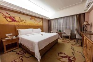 a bedroom with a large bed in a hotel room at Vienna Hotel Inner Mongolia Hohhot Railway Station Gongzhufu Metro Station in Hohhot