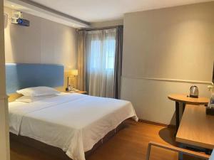 a bedroom with a large white bed and a table at JTOUR Inn Wuhan Wusheng Road Metro CapitaLand Plaza in Wuhan +115 photos