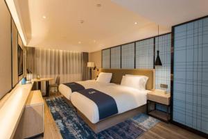a bedroom with a large bed and a bath tub at Echarm Hotel Guangzhou Yongqingfang Zhongshan 8th Road Metro Station in Guangzhou