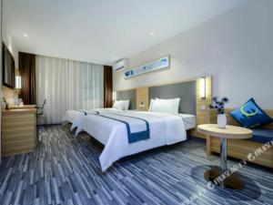 a large hotel room with two beds and a table at City Comfort Inn Guiyang Yan'an Middle Road Fountain Metro Station in Guiyang +246 photos