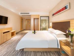 a bedroom with a large white bed and a television at City Comfort Inn Hefei Shuanggang Fuyang Road in Hefei +107 photos