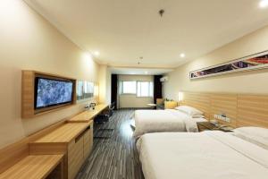 a hotel room with two beds and a flat screen tv at City Comfort Inn Wuhan Dream Times Baotong Temple Metro Station in Wuhan