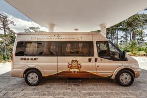 a small van parked in front of a building at Dalat Palace Heritage Hotel in Da Lat