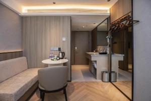 a living room with a couch and a table at Starway Hotel(Shuiximen Street,Nanjing) in Nanjing +251 photos
