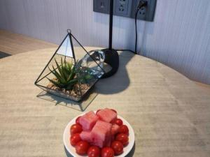 a plate of fruit on a table with a bowl of watermelon at Echarm Hotel Guilin Railway Station the MixC in Guilin