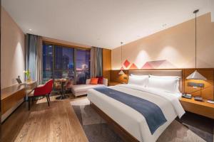 une chambre d'hôtel avec un grand lit et un bureau dans l'établissement Borrman Hotel Ji'nan Aoti Center East Provincial Hospital, à Jinan 266 autres photos