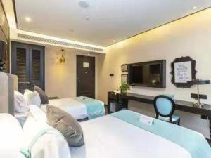 a hotel room with two beds and a flat screen tv at Xana Hotelle Xi'an Zhonglou Luoma in Xi'an
