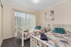a bedroom with two beds and a window at Rosebud Family Retreat in Rosebud