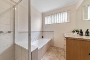 a bathroom with a bath tub and a sink at Rosebud Family Retreat in Rosebud