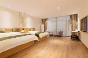 a hotel room with two beds and a large window at Green Tree Inn Nanchang Zhongshan Road Bayiguan in Nanchang