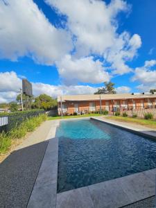 a swimming pool in front of a building at Bridge Motor Inn Tocumwal in Tocumwal