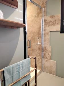 a shower in a bathroom with a chair at L Essentiel Studio climatisé 500m commerces et Voie Verte in Ruoms