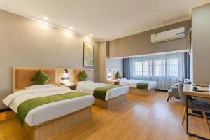 a hotel room with two beds and a desk at Green Tree Inn Hefei Railway Station International Auto Market Zhusitan Metro Station in Hefei +274 photos