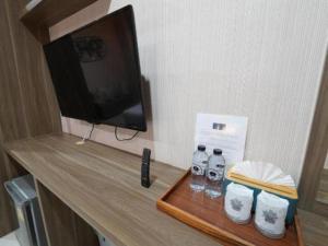 a table with two bottles of water and a television at RoomQuest Prachin Buri Rojana in Si Maha Phot +20 photos