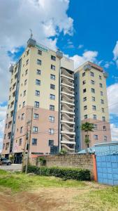 a large white building with a sign on it at Relax crib Membly Estate OJ in Ruiru