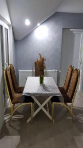 a table and chairs with a vase on top of it at Apartmani Kriva Drina in Okletac