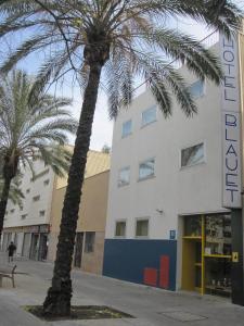 two palm trees in front of a building at Hotel Blauet by Bossh Hotels in El Prat de Llobregat